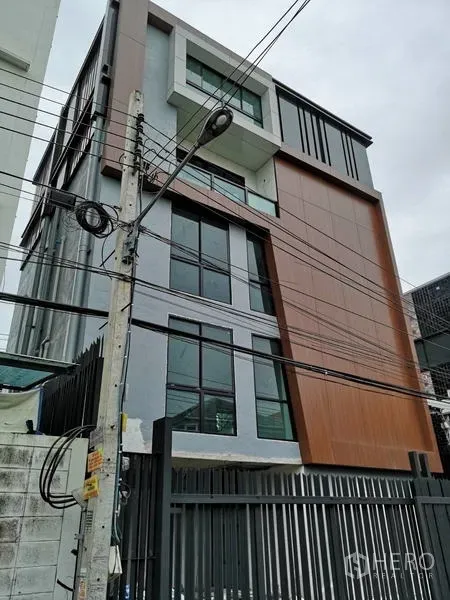 独立商业地产 出租在Chatuchak, Bangkok - 现代独栋办公楼外立面，大片玻璃窗与金属围栏。