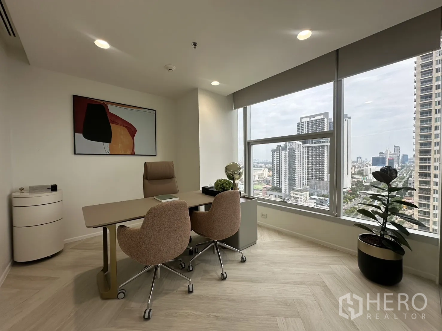 Office Space for rent in Sathon, Bangkok - Private executive office with desk, two guest chairs, wall art, and a large window facing the city.