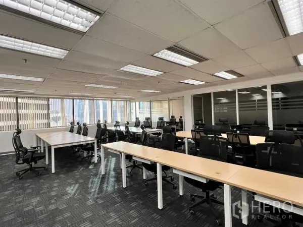 Office Space for rent in Khlong Toei, Bangkok - Spacious workspace with rows of desks and black task chairs, large windows, and glass-partitioned meeting rooms.