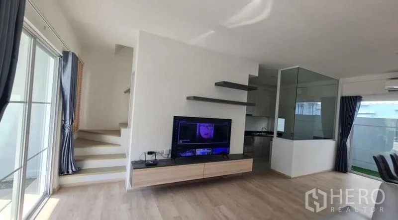 ทาวน์เฮาส์ ให้เช่าในPrawet, Bangkok - ห้องนั่งเล่นพร้อมชั้นวางทีวีแบบลอย ชั้นวางของ และบันไดขึ้นชั้นบน.