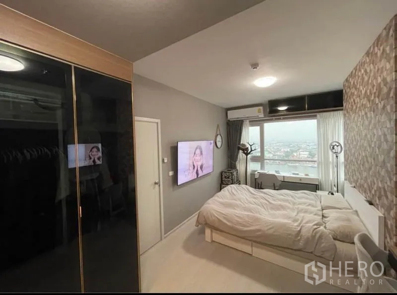 Condominium for sale in Bang Sue, Bangkok - Primary bedroom with large window, wall-mounted TV and expansive city outlook.