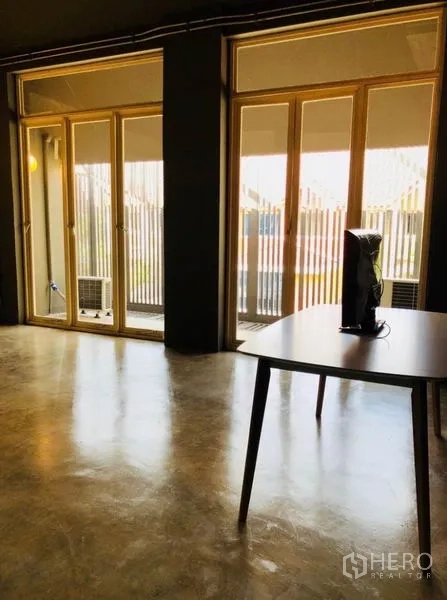 สำนักงานที่บ้าน ให้เช่าในHuai Khwang, Bangkok - ห้องอเนกประสงค์สว่างไสว ประตูกระจกบานใหญ่และพื้นปูน.