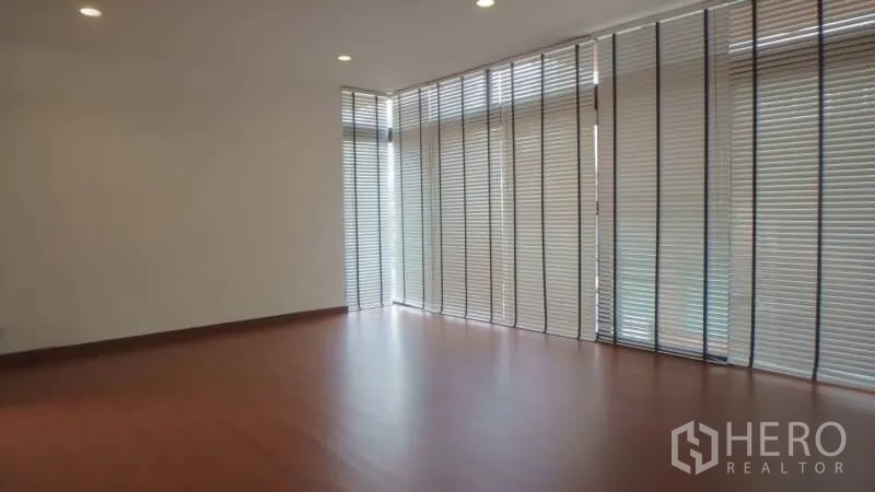 บ้าน ให้เช่าในWatthana, Bangkok - ห้องนั่งเล่นกว้าง พื้นไม้ พร้อมม่านบังตาเต็มความสูงและไฟดาวน์ไลท์