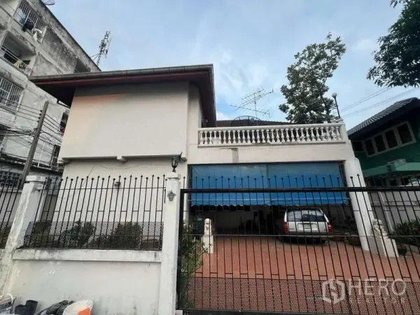 独立式住宅 出售在Phra Khanong, Bangkok - 两层独立屋正立面，带院门与车棚。