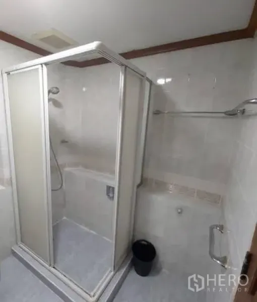 Condominium for rent in Samphanthawong, Bangkok - Bathroom with glass‑enclosed shower, white tiles, and metal fixtures.