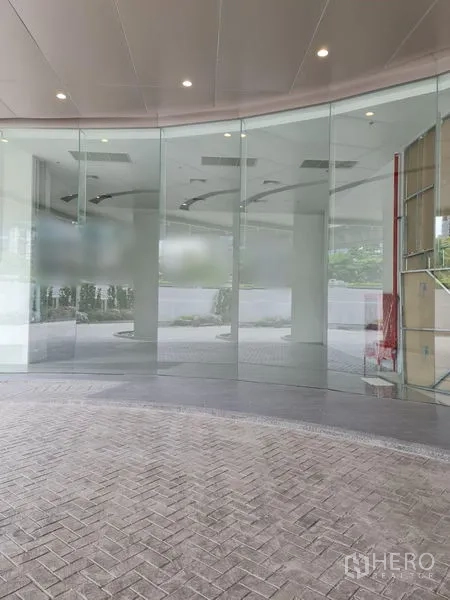 พื้นที่ขายปลีก ให้เช่า - หน้าร้านกระจกโค้งของพื้นที่ค้าปลีกชั้นล่าง พร้อมทางเข้าใต้หลังคา