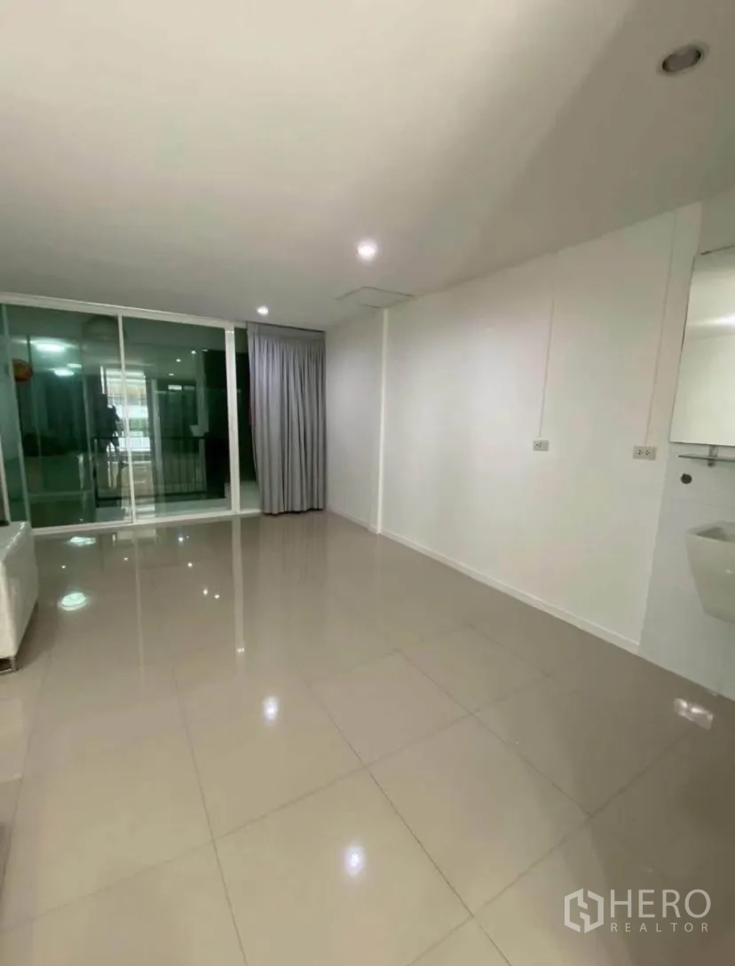 联排别墅 for rent in Phra Khanong, Bangkok - 楼上房间带推拉玻璃门与窗帘，通向阳台。