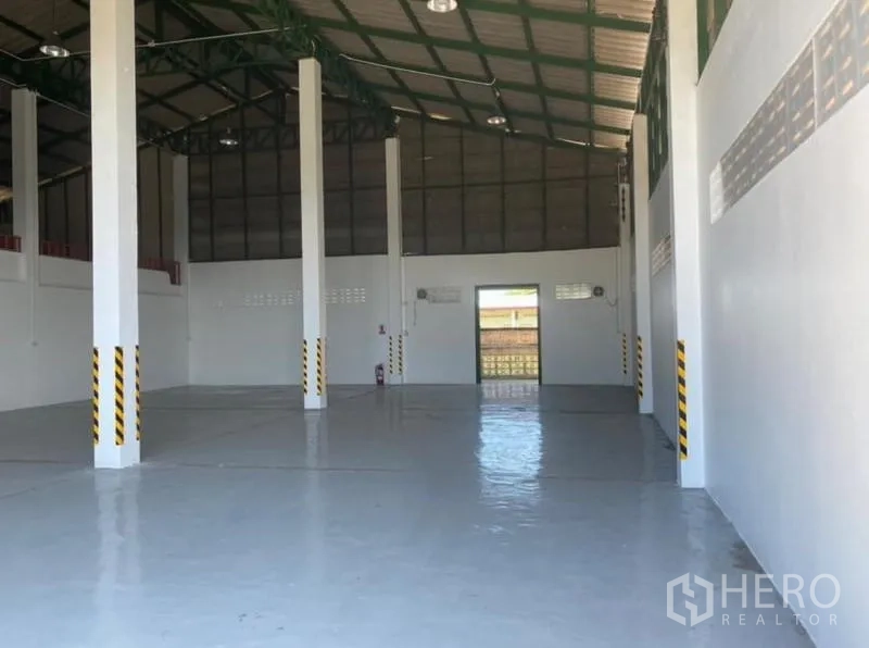 Warehouse for rent in Mueang Rayong, Rayong - Open warehouse interior showing a tall roof, steel trusses, and glossy epoxy-coated floor.