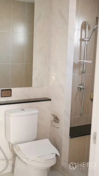 Detached House for rent or sale in Bang Bo, Samut Prakan - Bright bathroom with tiled shower, toilet and long vanity shelf.