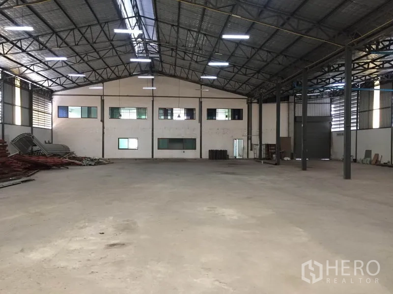货栈 出租在Saphan Sung, Bangkok - 宽敞仓库内景，钢结构高屋顶、混凝土地坪，后方连接带窗的办公室。