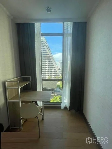 公寓 出租在Watthana, Bangkok - 落地窗旁的小书桌，可眺望城市景观。