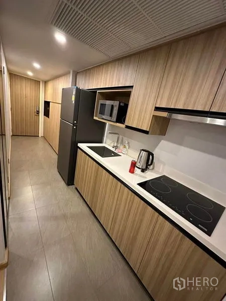 公寓 出租在Pathum Wan, Bangkok - 狭长走廊式厨房，配置齐全并有吊顶通风口。