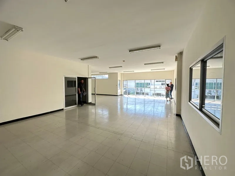 工厂 出租在Si Racha, Chon Buri - 二楼宽敞办公室，落地窗视野佳，瓷砖地面与日光灯，面向停车区。