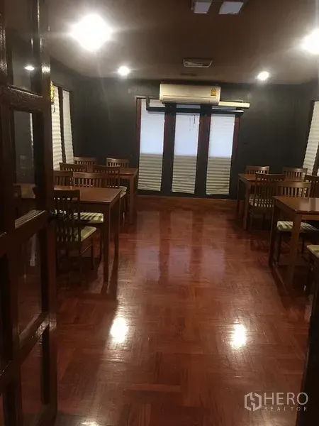 零售空间 出租在Khlong Toei, Bangkok - 宽敞用餐厅，木质桌椅、拼花地板与顶灯照明。
