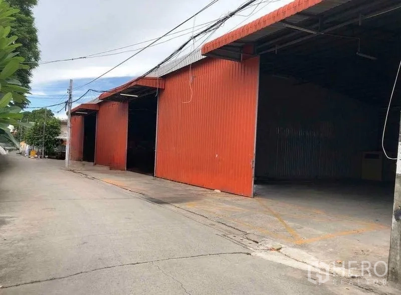 Warehouse for rent in Bang Kapi, Bangkok - Row of red warehouse bays with open doors and easy on-street truck access.