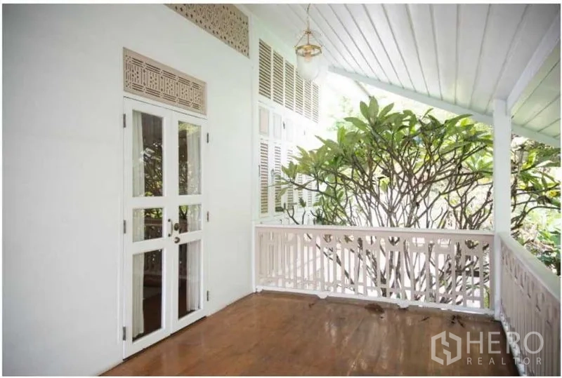 Detached House for rent in Bang Rak, Bangkok - Shaded balcony with double doors and greenery beside the railing.