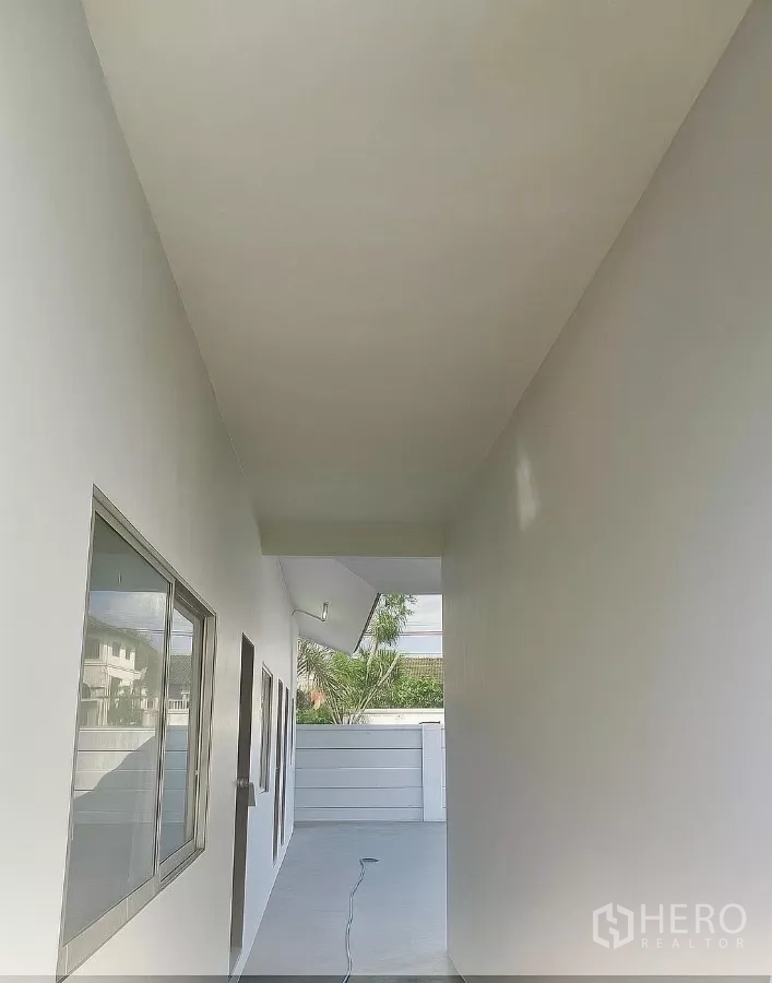 Home Office for rent in Bang Phli, Samut Prakan - Covered side corridor with windows along the building leading to the front gate.