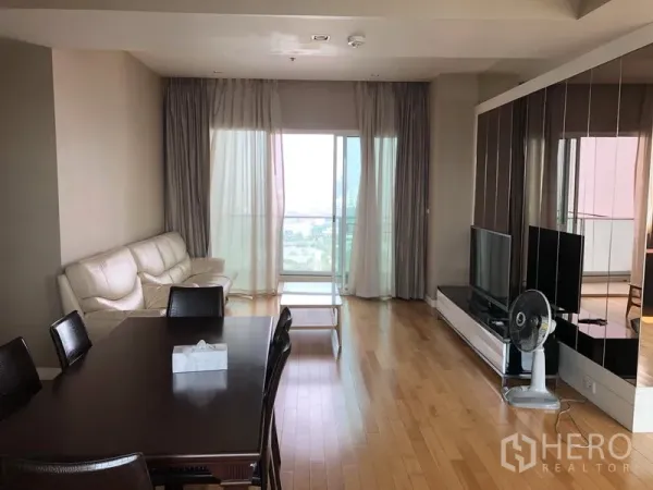 คอนโด ให้เช่าในKhlong Toei, Bangkok - ห้องนั่งเล่นและรับประทานอาหารพื้นไม้ พร้อมโซฟา ทีวี และระเบียงวิวเมือง