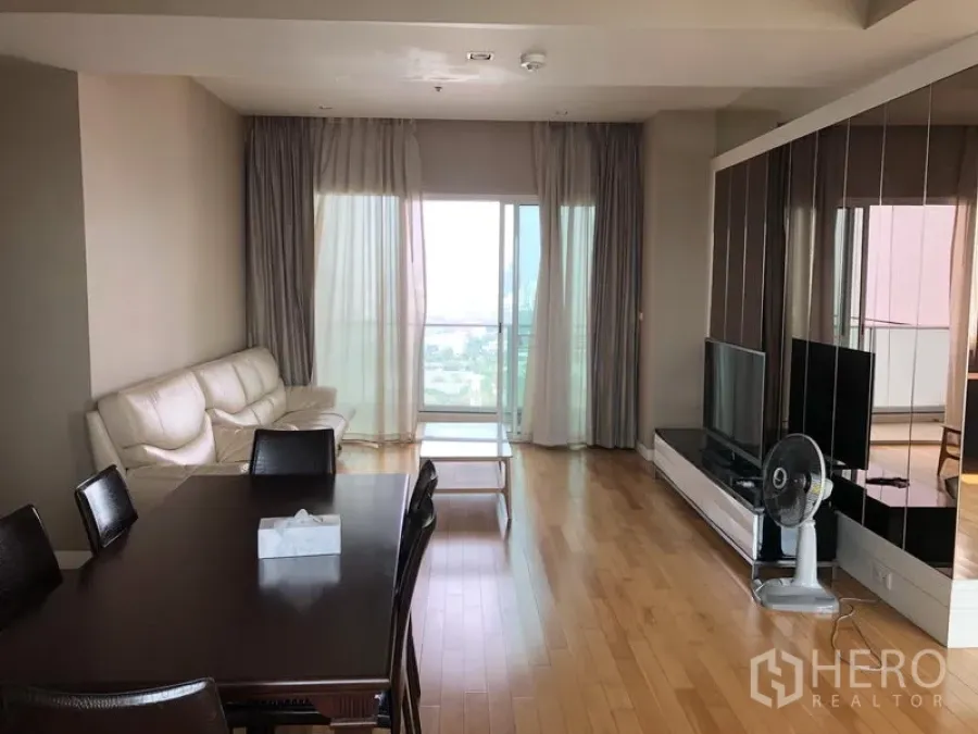 คอนโด ให้เช่าในKhlong Toei, Bangkok - ห้องนั่งเล่นและรับประทานอาหารพื้นไม้ พร้อมโซฟา ทีวี และระเบียงวิวเมือง