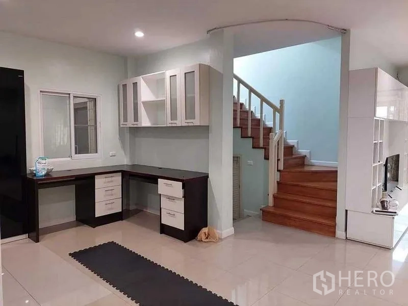 Detached House for sale in Bueng Kum, Bangkok - Ground-floor space with built-in corner desk and wooden staircase.