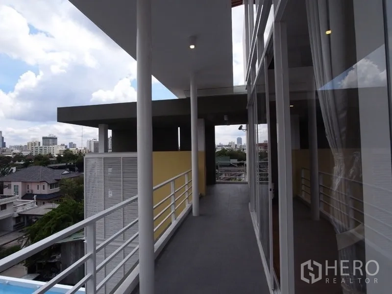 公寓 出租在Chatuchak, Bangkok - 加盖长廊式阳台，白色栏杆与城市天际线景观。