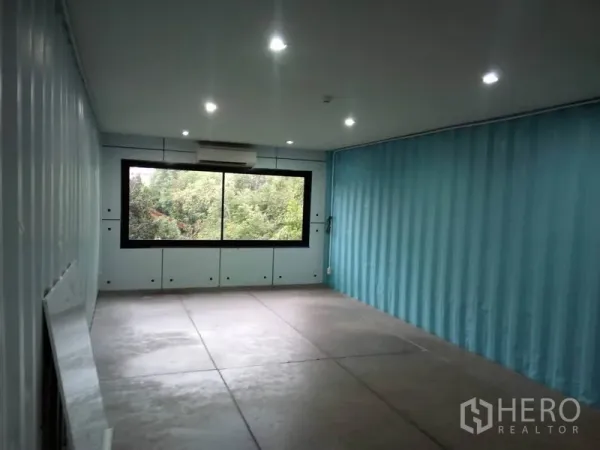 零售空间 出租在Khlong Toei, Bangkok - 宽阔店面朝向大窗，水泥地与天花筒灯。