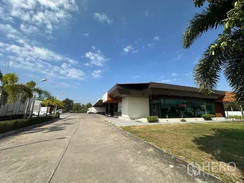 คลังสินค้า ให้เช่าในLam Luk Ka, Pathum Thani - อาคารสำนักงานกระจกสมัยใหม่พร้อมถนนภายในและต้นปาล์มจัดสวน