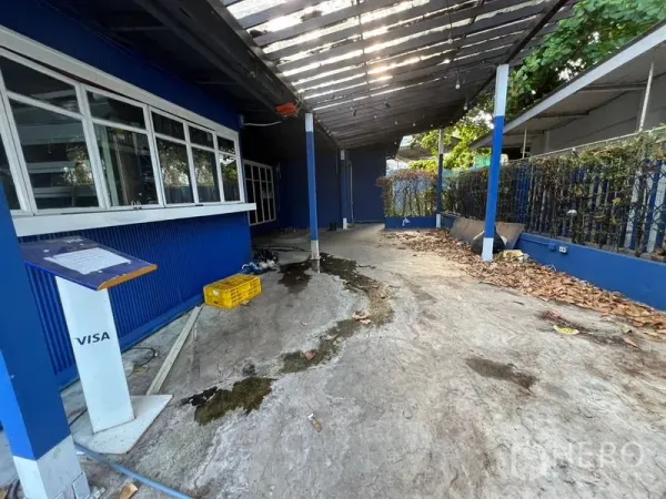 零售空间 出租在Watthana, Bangkok - 带顶棚的室外走道与服务窗口，蓝色外墙