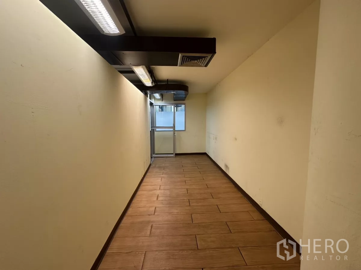 คลังสินค้า ให้เช่า - ห้องอเนกประสงค์/ทางเดินแคบ พื้นลายไม้ ไฟหลอดฟลูออเรสเซนต์ และประตูกระจกด้านหน้า