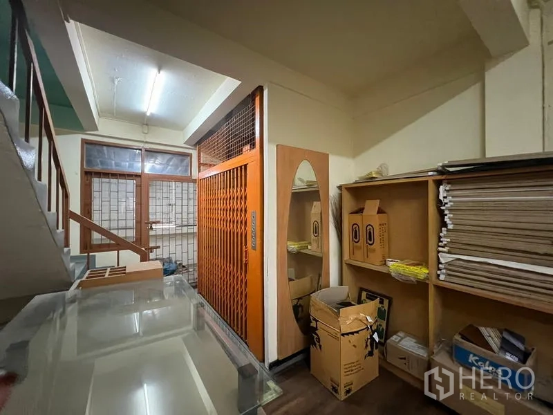 อาคารพาณิชย์ ให้เช่าหรือขายในWatthana, Bangkok - โถงชั้นพักบันไดพร้อมชั้นวางของ และประตูลิฟต์ขนของสีส้ม.