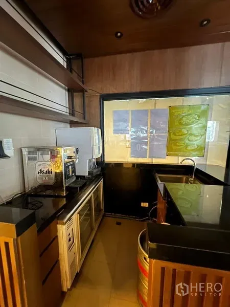 พื้นที่ขายปลีก ให้เช่า - สเตชันบาร์กะทัดรัด เคาน์เตอร์หินดำ ชั้นวาง และเครื่องดื่มพร้อมเสิร์ฟ.