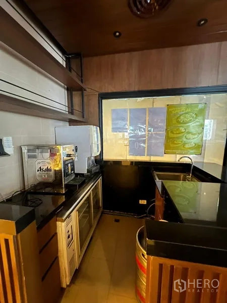 พื้นที่ขายปลีก ให้เช่า - สเตชันบาร์กะทัดรัด เคาน์เตอร์หินดำ ชั้นวาง และเครื่องดื่มพร้อมเสิร์ฟ.