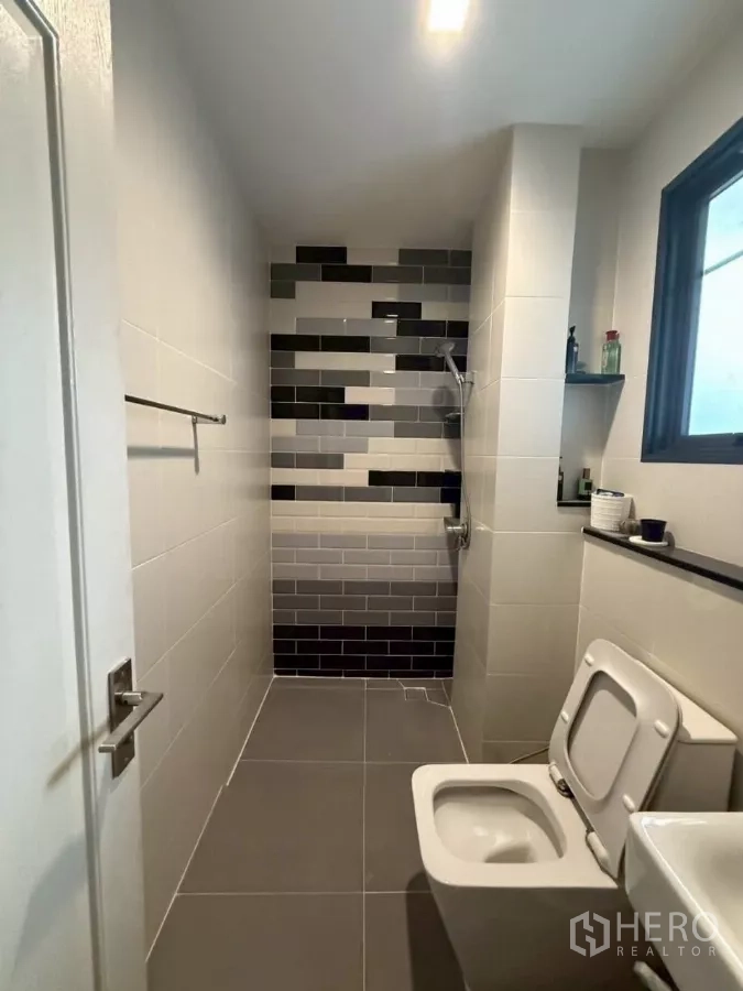 Detached House for rent or sale in Bang Phli, Samut Prakan - Contemporary bathroom with monochrome subway‑tile shower wall and toilet.