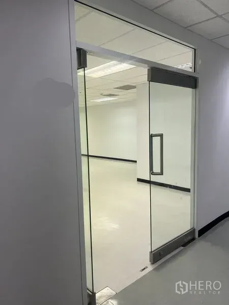 สำนักงาน ให้เช่าในWatthana, Bangkok - ประตูกระจกบานเลื่อนเปิดสู่สำนักงานสว่างโทนขาวพร้อมไฟฝ้าทีบาร์