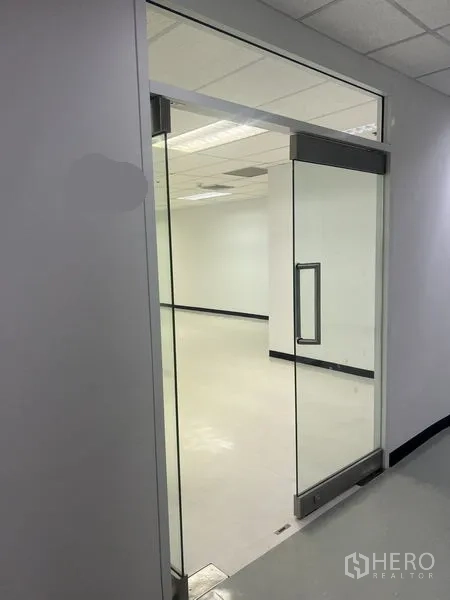 สำนักงาน ให้เช่าในWatthana, Bangkok - ประตูกระจกบานเลื่อนเปิดสู่สำนักงานสว่างโทนขาวพร้อมไฟฝ้าทีบาร์