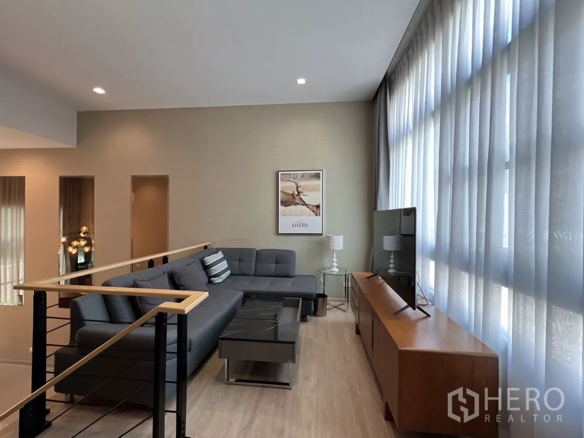 ทาวน์เฮาส์ ให้เช่าในSuan Luang, Bangkok - ห้องนั่งเล่นสว่างด้วยหน้าต่างสูงจรดเพดาน โซฟาและทีวี