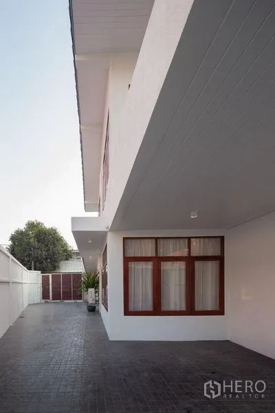 独立式住宅 出售在Chatuchak, Bangkok - 侧立面展示私密长车道与围墙。