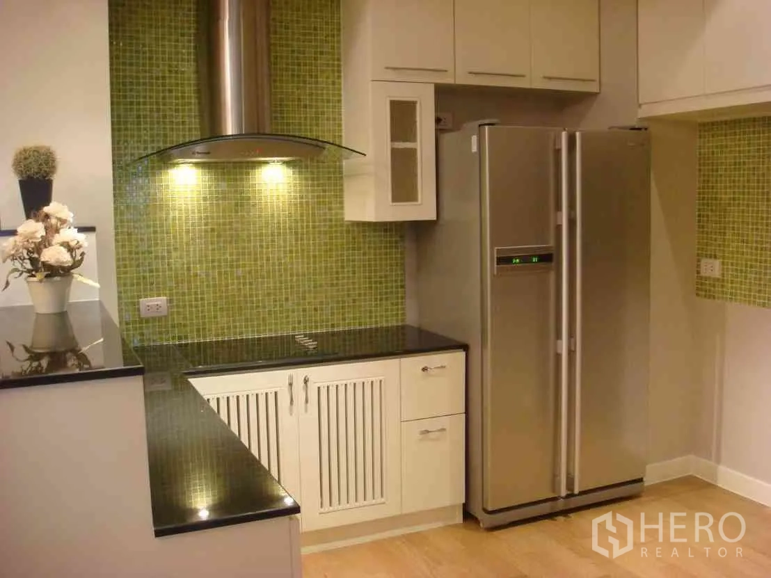 Condominium for rent in Watthana, Bangkok - Fitted kitchen with green mosaic backsplash, stovetop and hood, and a stainless side-by-side fridge.
