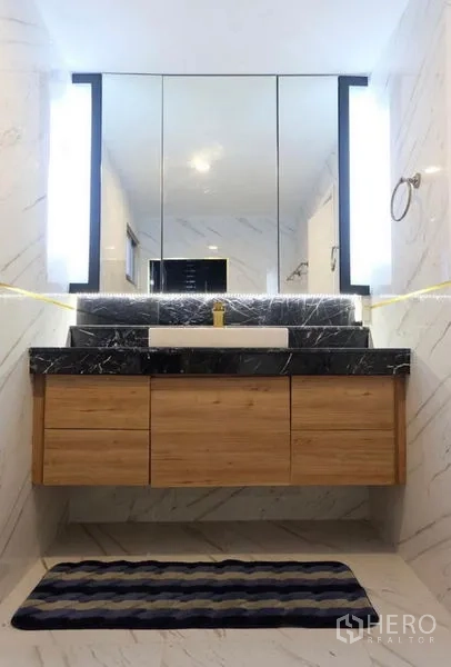 Detached House for rent in Suan Luang, Bangkok - Contemporary bathroom vanity with black marble countertop, wood drawers, and backlit mirror.