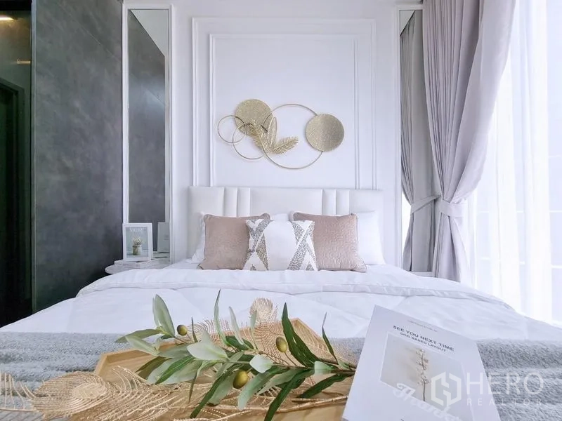 公寓 出售 - 床与软包床头特写，墙面装饰与靠枕。