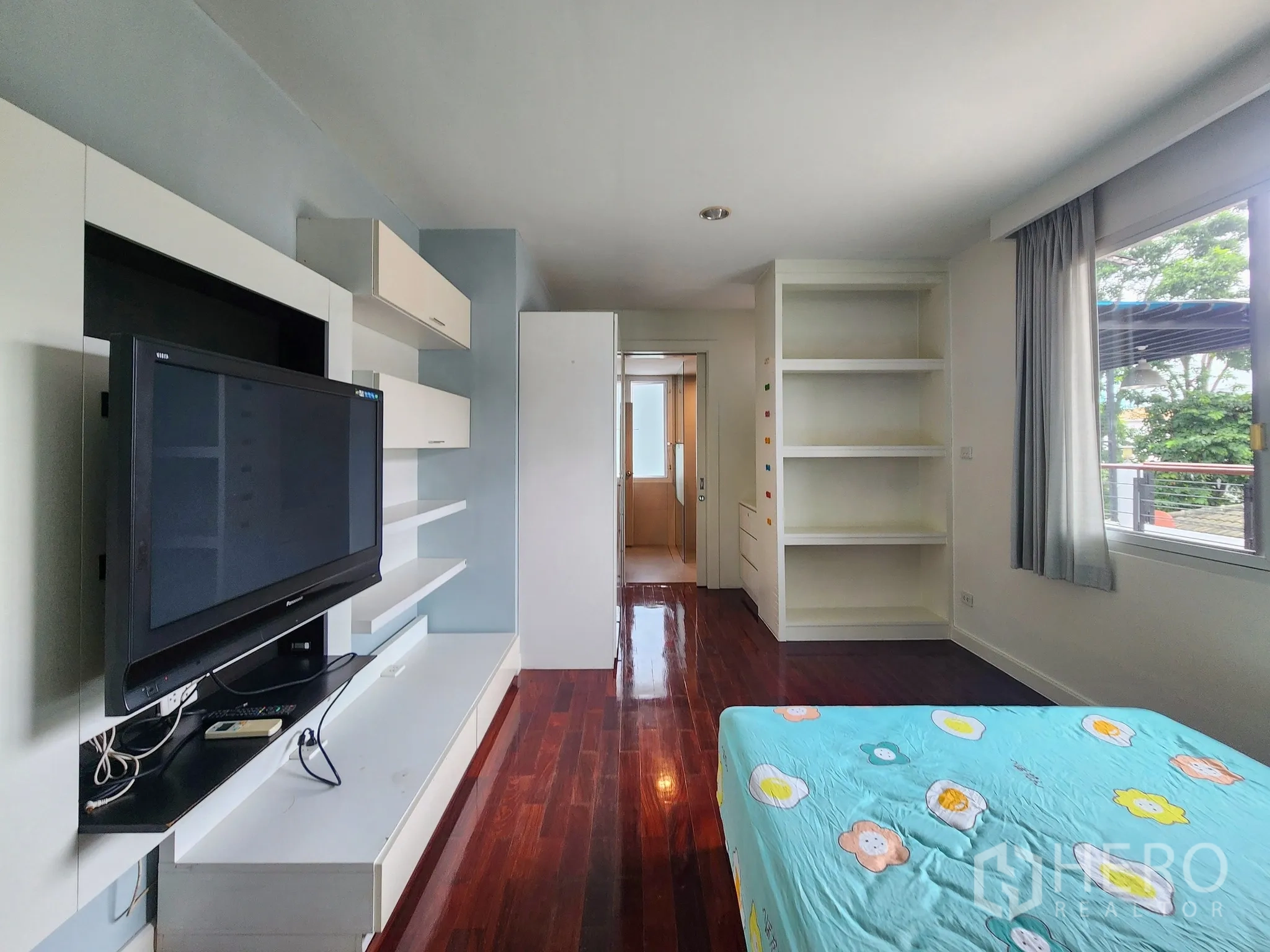 独立式住宅 出租在Bang Kapi, Bangkok - 第三卧室另一角度，可见阳台视野与亮泽木地板。