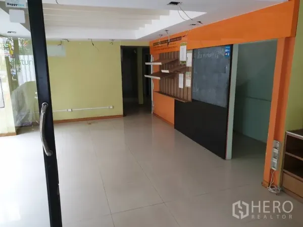 พื้นที่ขายปลีก ให้เช่าในWatthana, Bangkok - พื้นที่ค้าปลีกชั้นล่างแบบเปิดโล่ง พื้นกระเบื้อง ประตูกระจก และผนังสีส้ม