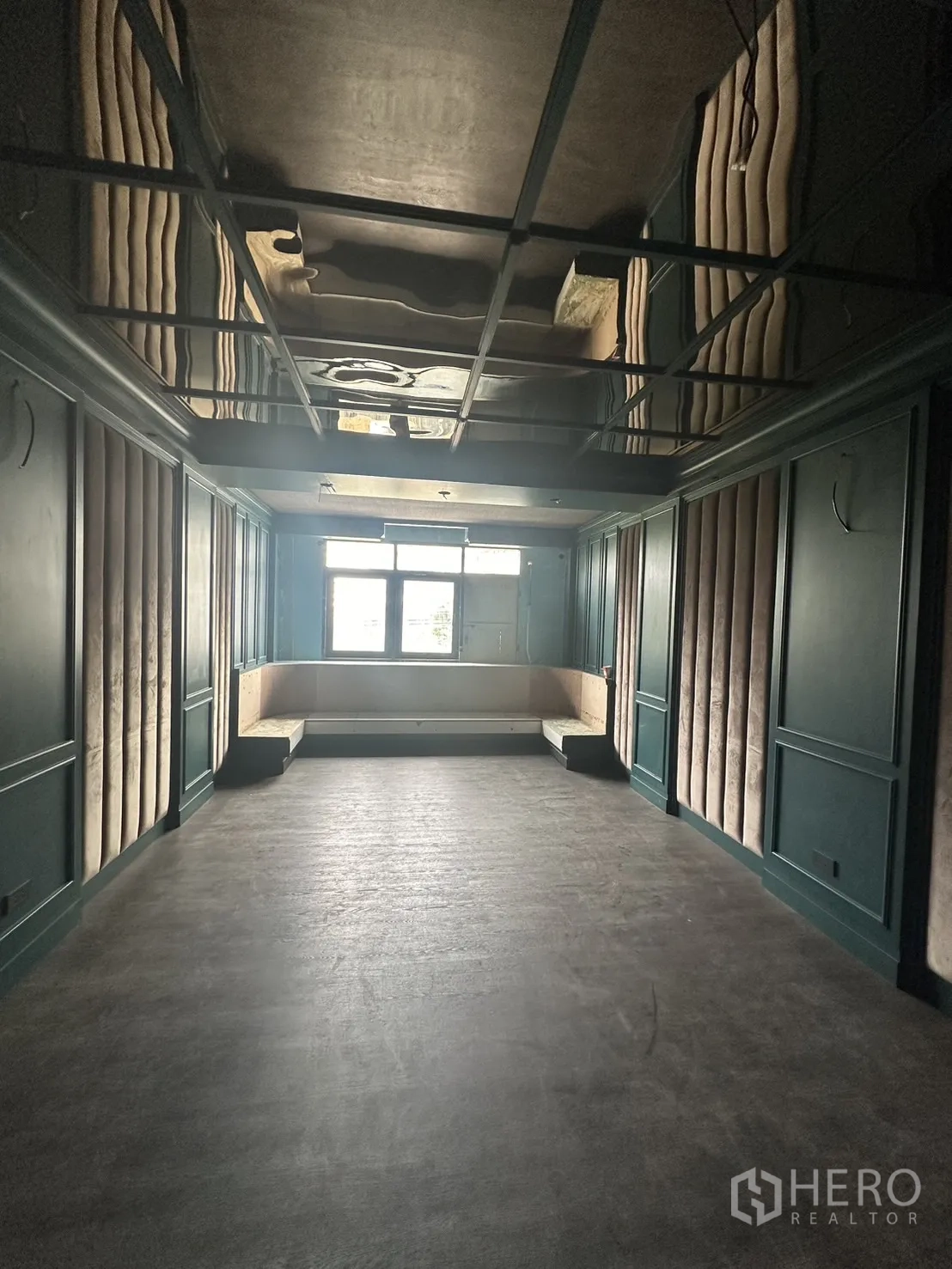 店屋 出租在Watthana, Bangkok - 楼上房间，深绿墙面、镜面格栅天花与前方窗边座位。