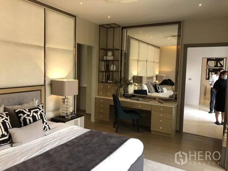 独立式住宅 出售在Bang Kapi, Bangkok - 卧室带内置梳妆书桌与大镜面，暖色系装饰。