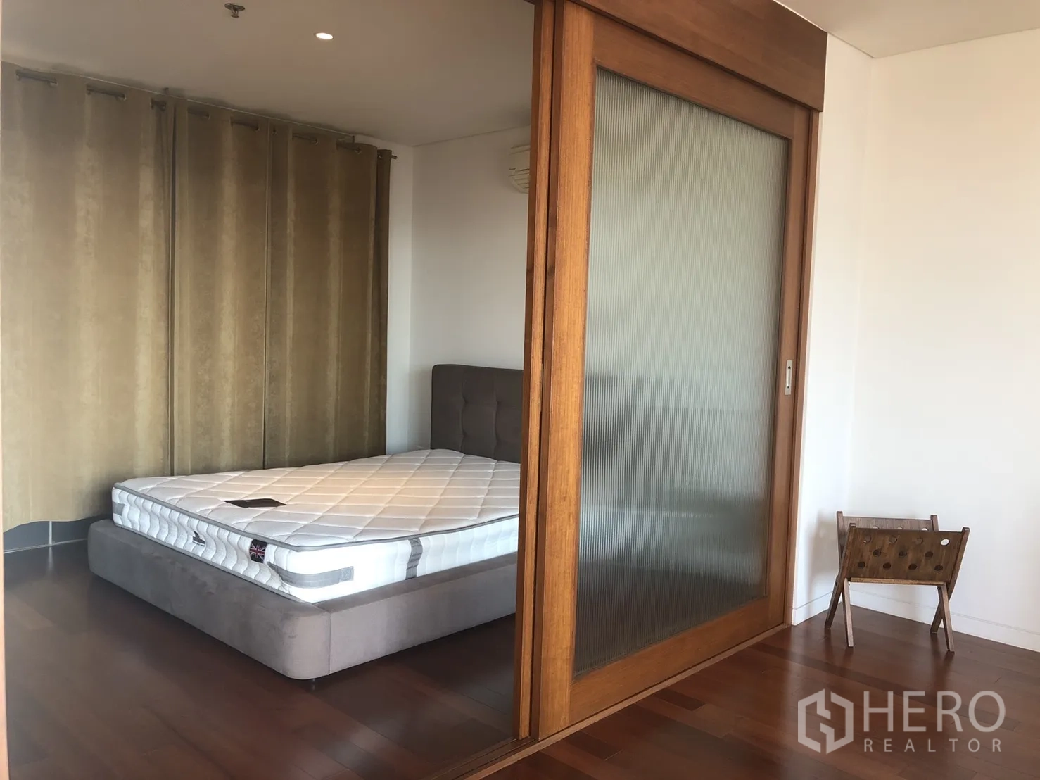 公寓 出租在Pathum Wan, Bangkok - 透过木框推拉玻璃门可见卧室，设长窗帘与实木地板