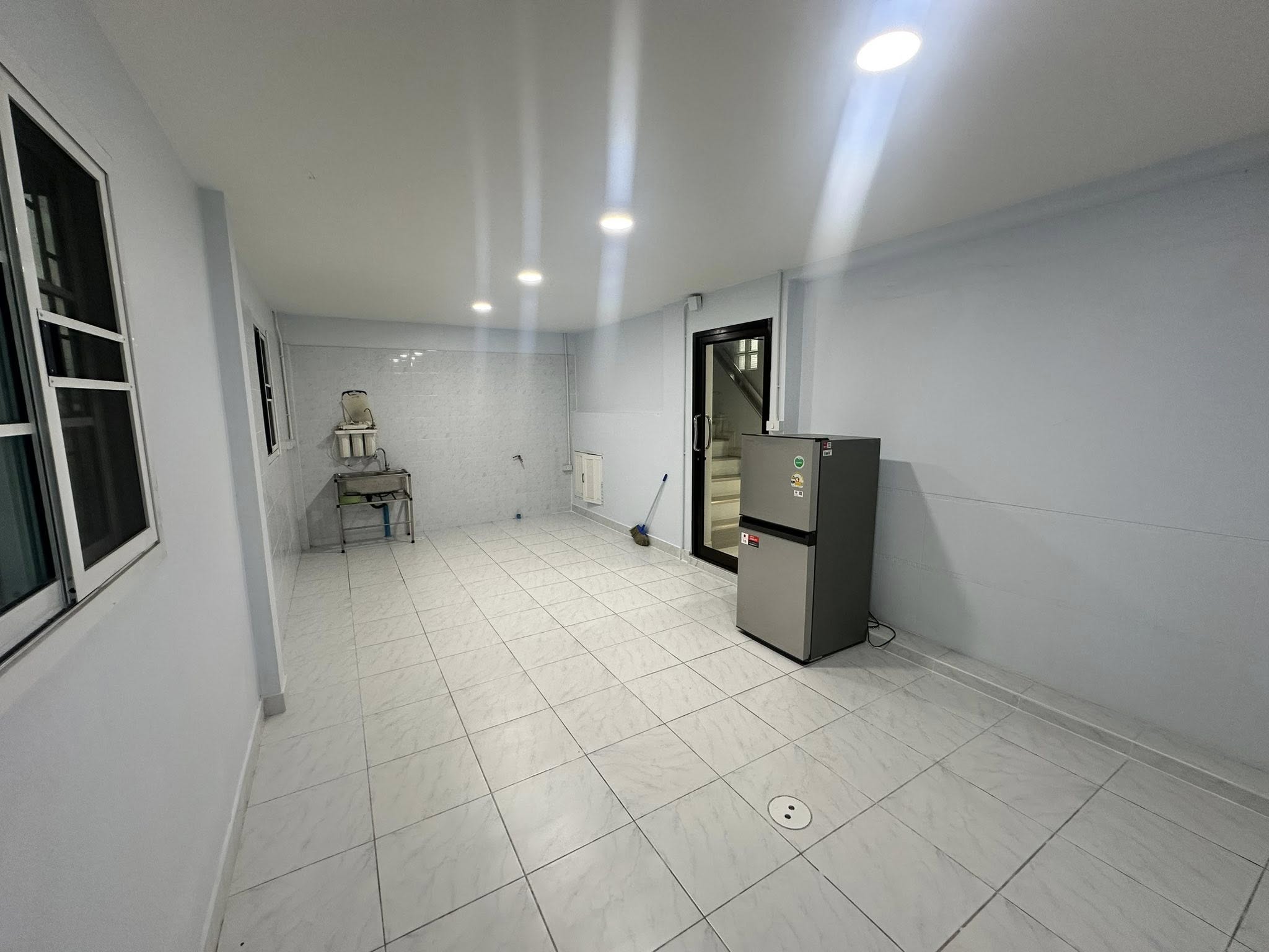 带办公室的家 出租在Wang Thonglang, Bangkok - 厨房另一视角，不锈钢水槽、窗户与嵌灯。