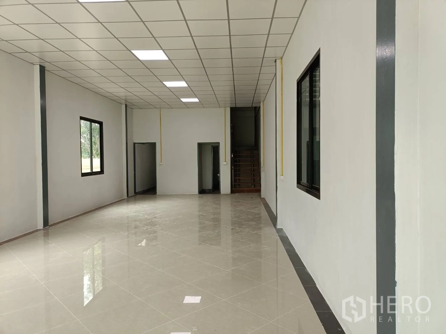 โรงงาน ให้เช่าในLam Luk Ka, Pathum Thani - มุมมองโถงสำนักงานไปยังบันได เพดานไฟและหน้าต่างหลายบาน