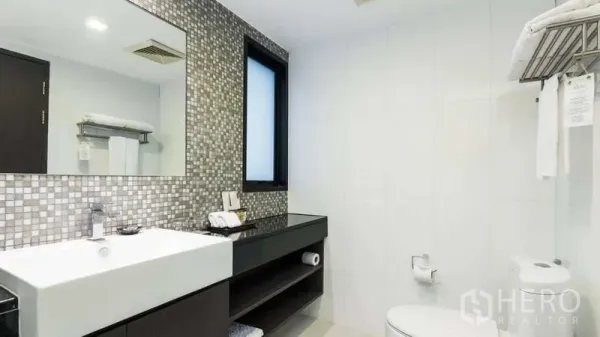 Apartment for rent in Watthana, Bangkok - Second bathroom with large mirror, vanity storage and towel rack.