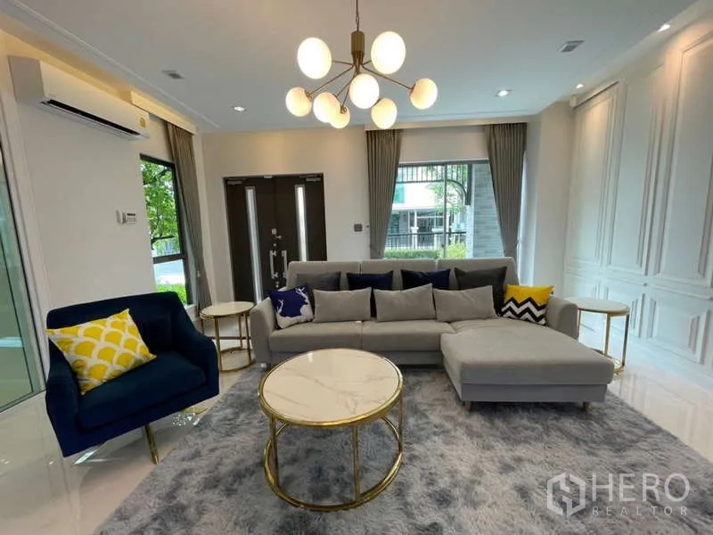 บ้าน ให้เช่าหรือขายในLat Krabang, Bangkok - ห้องนั่งเล่นหลักมีโซฟาเข้ามุม โต๊ะกลางโทนทอง และโคมไฟโมเดิร์น