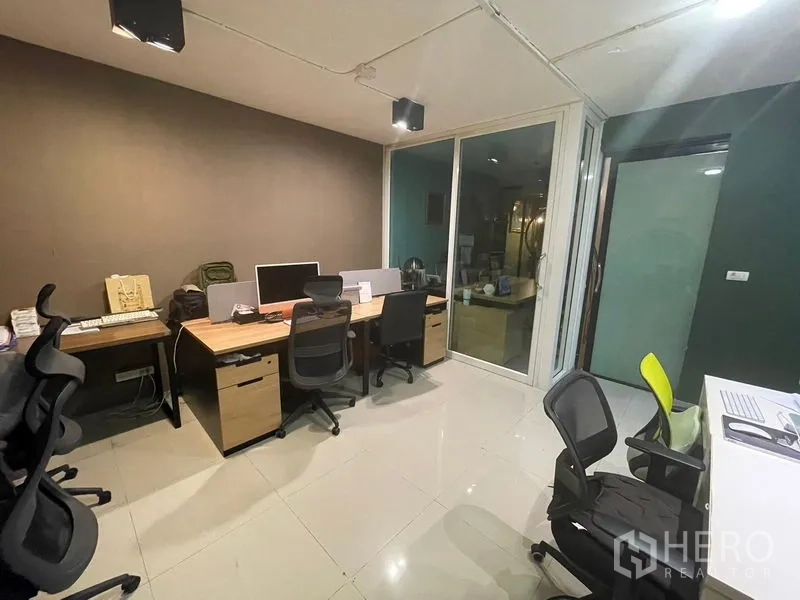 Home Office for sale - Workstation room with multiple ergonomic chairs and wooden desks beside a glass partition.